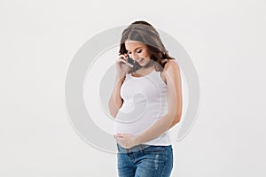 Smiling pregnant woman talking by mobile phone