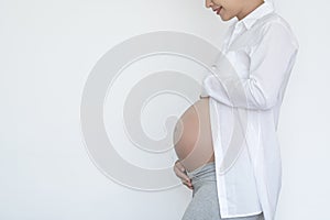 Smiling Pregnant woman in white shirt isolated on white