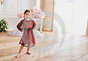 Smiling pretty barefoot girl in festive dress