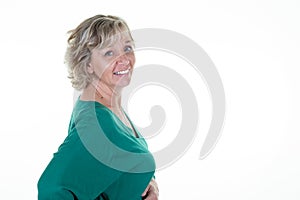 Smiling pretty blond senior woman in green sweater middle aged in copy space on white background