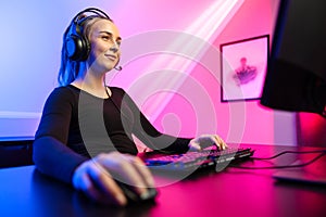 Happy and Beautiful Blonde Gamer Girl Playing Online Video Game on Her Personal Computer.