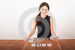 Smiling pretty girl - kid playing poker with money