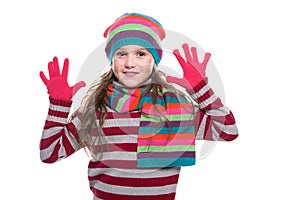 Smiling pretty little girl wearing colorful knitted scarf, hat and gloves isolated on white background. Winter clothes.