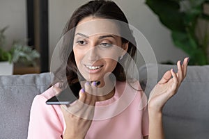 Smiling pretty millennial arabic indian woman recording audio message.