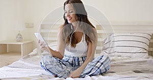 Smiling pretty woman listening to music at home