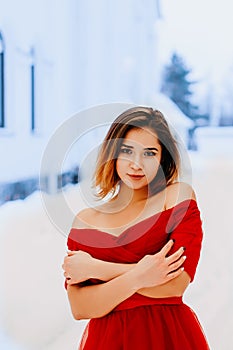 Smiling pretty young woman in beautiful shawl posing in a winter forest or park