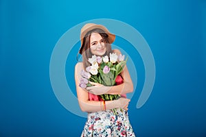 Smiling pretty young woman holding bouquet of flowers