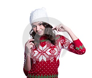 Smiling pretty young woman wearing colorful knitted sweater with christmas ornament and hat. Isolated on white background.