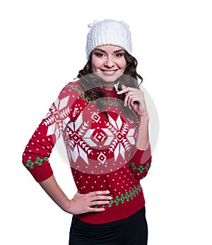 Smiling pretty young woman wearing colorful knitted sweater with christmas ornament and hat. Isolated on white background.