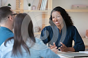 Smiling professional african american financial advisor talking to clients.