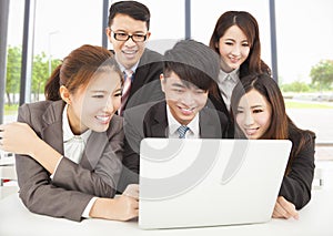 Smiling professional asian business team working in office