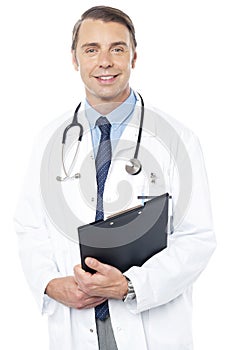 Smiling professional physician carrying clipboard