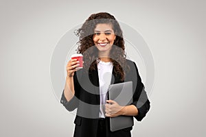 Smiling professional woman with coffee and laptop photo