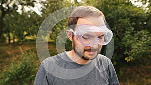 Smiling professionallawn mower wearing transparent glasses protection and and isolating headphones.