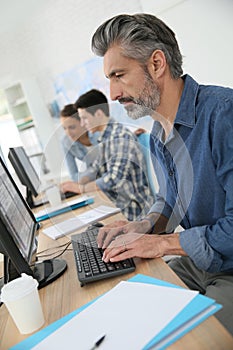 Smiling professor working on desktop computer
