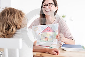 Smiling psychologist picture and child in a family support centre