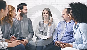 Smiling Psychologist Talking To Group Members At Therapy Session In Rehab