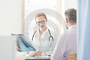 Smiling pulmonologist watching x-ray image photo