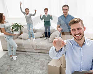 Smiling realtor with keys on the background of a new apartment