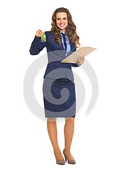 Smiling realtor woman with clipboard giving keys