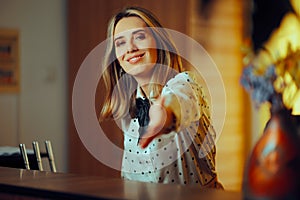 Smiling Receptionist Greeting with a Handshake at her Desk