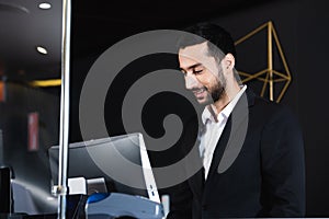 smiling receptionist working near computer monitor