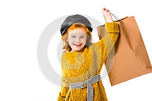 smiling red hair child holding shopping bag in hand