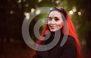 Smiling red hair woman in autumn park