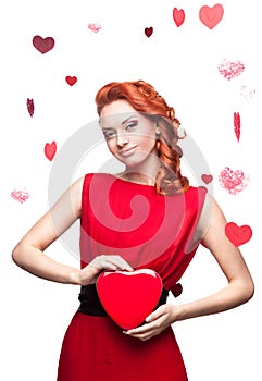 Smiling red-haired girl holding red heart