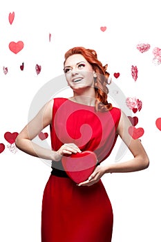 Smiling red-haired girl holding red heart