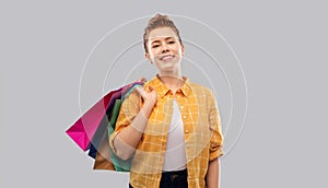 Smiling red haired teenage girl with shopping bags