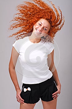 Smiling red haired woman with hair flying