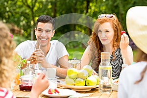 Smiling red-haired woman and spanish man enjoying outdoor party