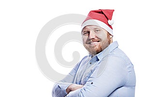 Smiling redhead man in santa claus hat. New Year and Christmas celebration. Isolated on a white background. Space for text