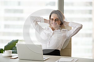 Smiling relaxed businesswoman watching funny online video at wor