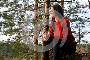 Smiling relaxed woman hiker sitting on hill admiring nature in mountain forest.