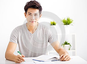 Smiling relaxed young man reading book