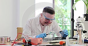 Smiling researcher uses magnifying glass to inspect detail