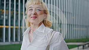 Smiling retired businesswoman walking street closeup. Happy woman looking camera