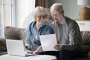Smiling retired couple read good news in paper notification photo