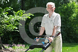 Smiling retiree with lawn mower