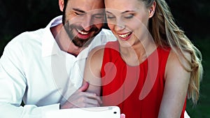 Smiling romantic couple using digital tablet