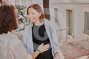 Smiling romantic hipster couple in love talking each other while walking on city street