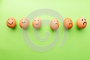 Smiling and sad eggs on a green background