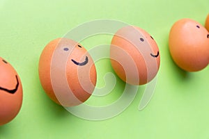 Smiling and sad eggs on a green background