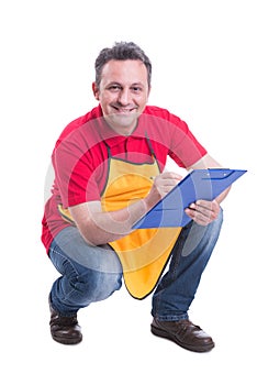 Smiling salesman counting products on supermarket shelf