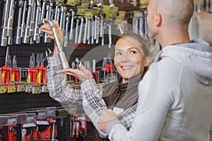 Smiling saleswoman showing different tools and instruments in wholesale