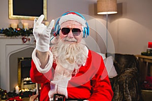 Santa claus listening to music on headphones at home