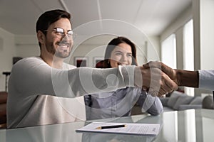 Smiling satisfied millennial man shake hands with insurance agent