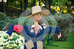 Smiling scarecrow in a vegetable garden in a countryside.